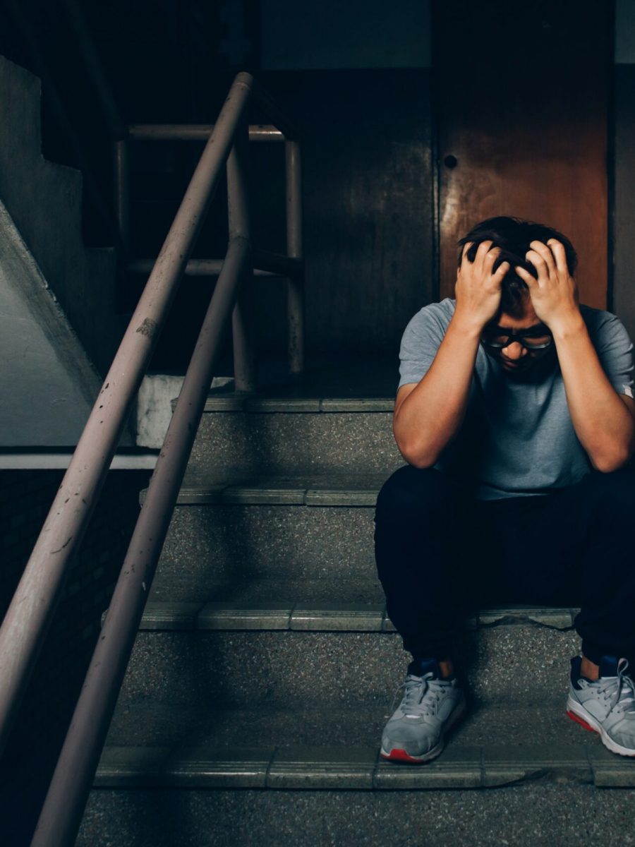 depressed-man-sitting-stairs-building-holding-his-forehead-while-having-headache (1)